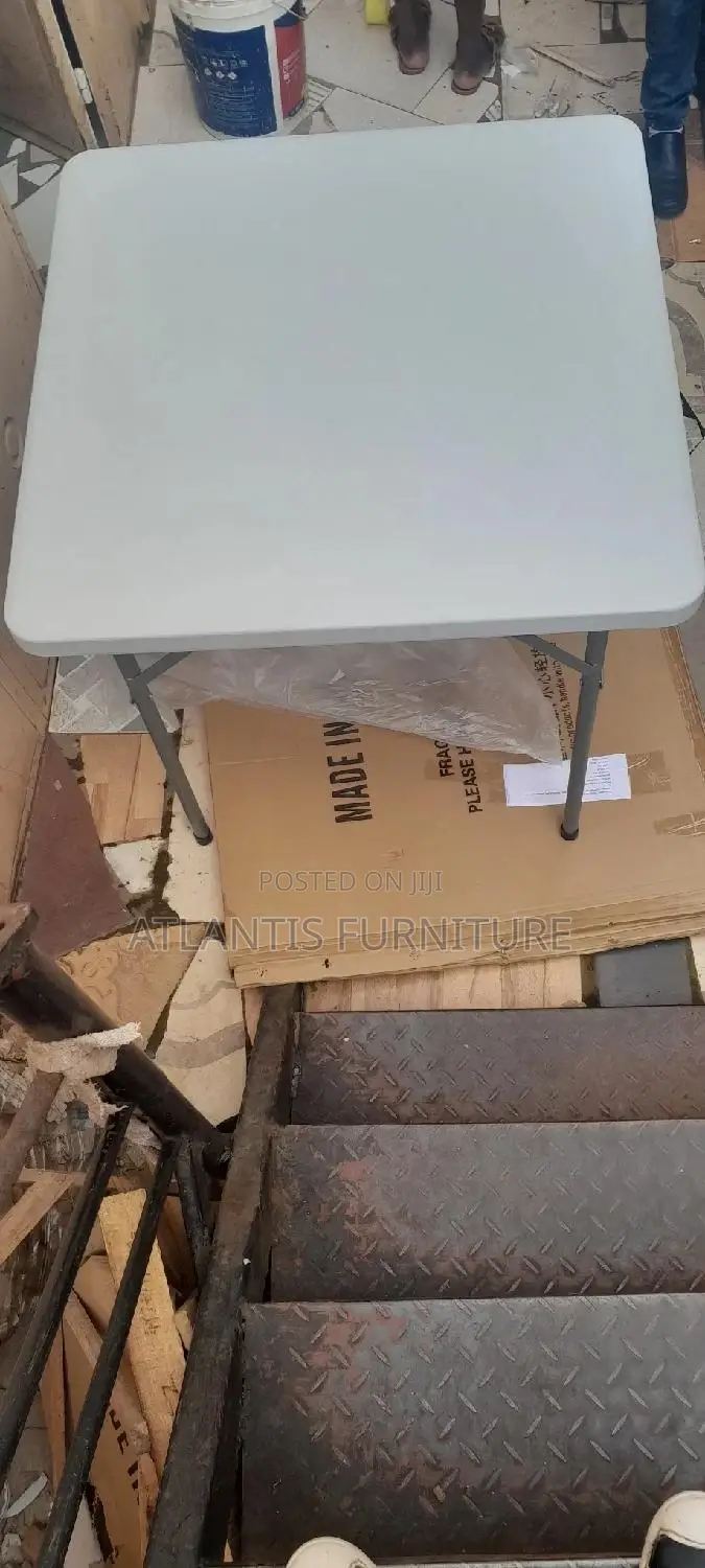 A Foldable Plastic Table 84by84cm With Steel Legs.