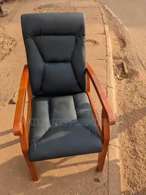 A Highly Crafted Leather Chair With Wooden Arms and Legs