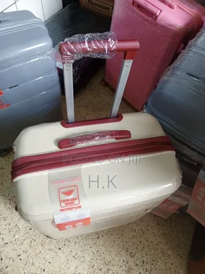 Beige Hard-Shell Suitcase With Spinner Wheels.