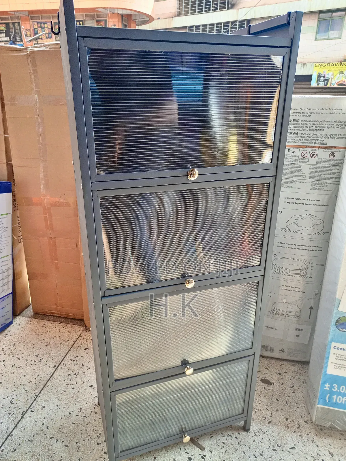Grey Metal Storage Cabinet With Four Glass-Paned Doors.