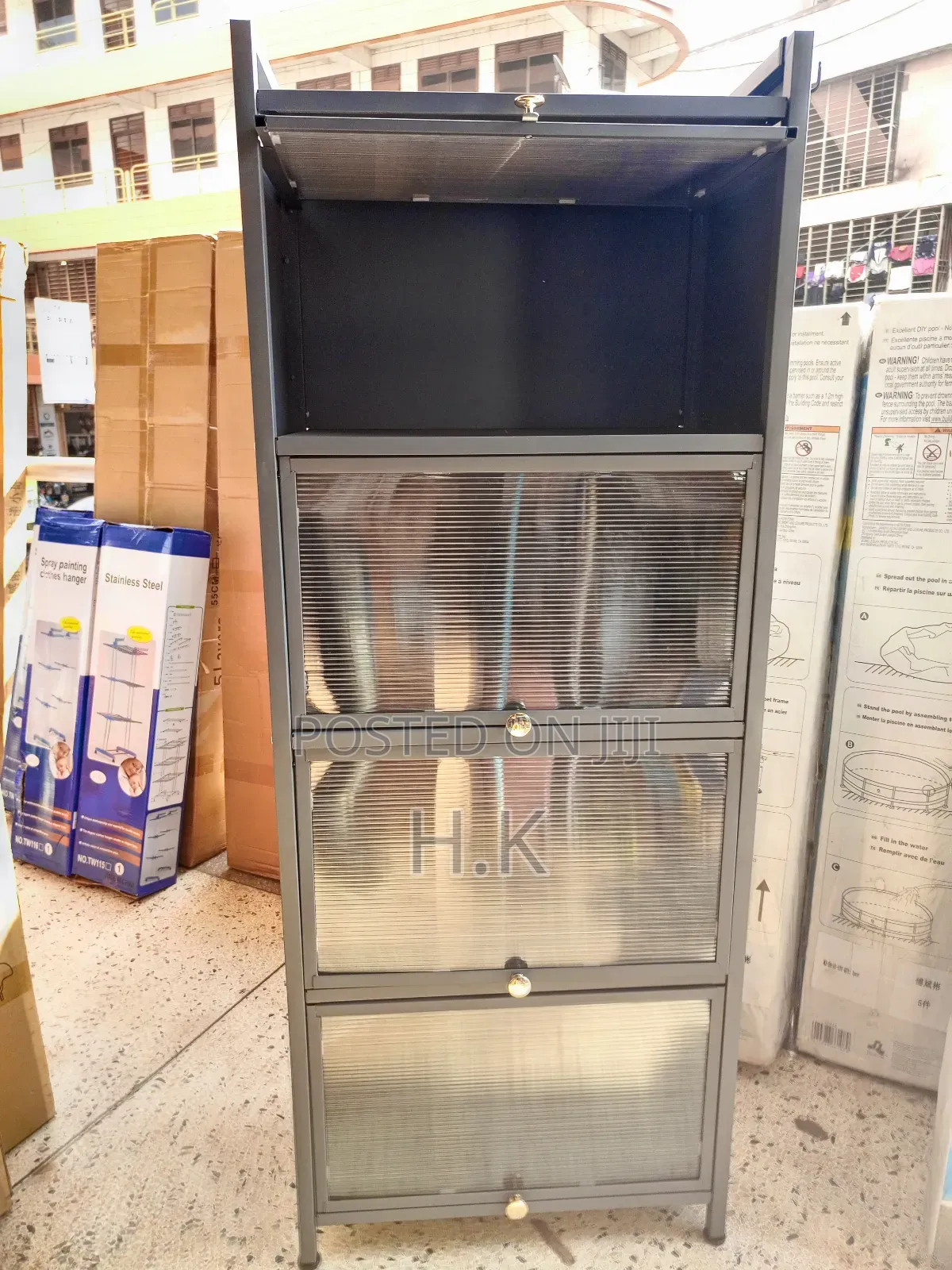 Grey Metal Storage Cabinet With Four Glass-Paned Doors.