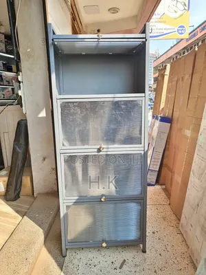 Grey Metal Storage Cabinet With Four Glass-Paned Doors.