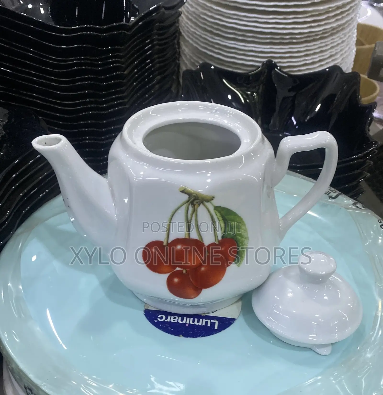 A Round Ceramic White Tea Pot With a Flower