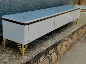Well Furnished Tv Stand in White With a Mable on Top and Golden Legs
