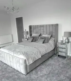 A Light Gray Colored Bed With a Mattress