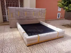 A Light Gray Colored Bed With Golden Lines Design