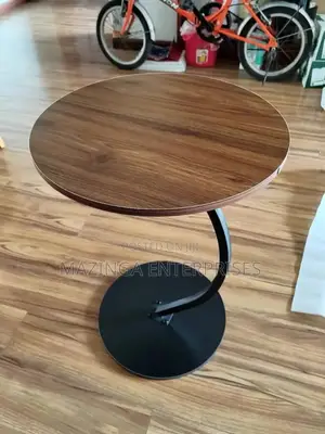 C-Shaped Side Table With a Round Wooden Top and a Black Metal Base.