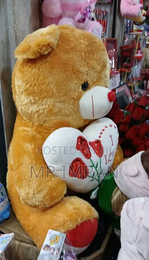 Large, Brown Plush Teddy Bear Holding a Heart Pillow.