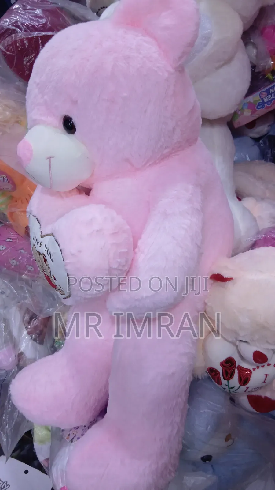 Large Pink Plush Teddy Bear Holding a Heart Pillow.