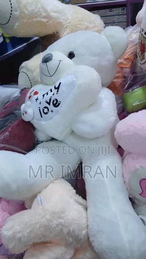 Large Pink Plush Teddy Bear Holding a Heart Pillow.