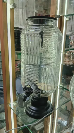 Ribbed Glass Beverage Dispenser With a Black Plastic Lid and Spigot.
