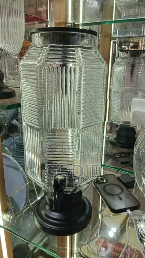 Ribbed Glass Beverage Dispenser With a Black Plastic Lid and Spigot.