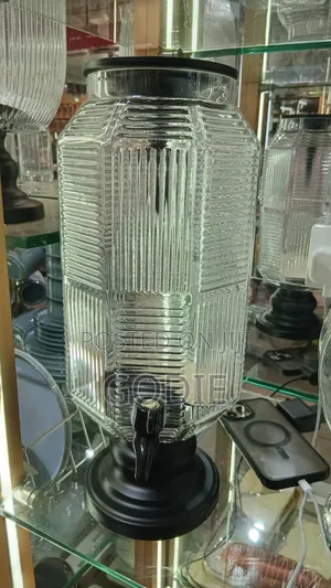 Ribbed Glass Beverage Dispenser With a Black Plastic Lid and Spigot.