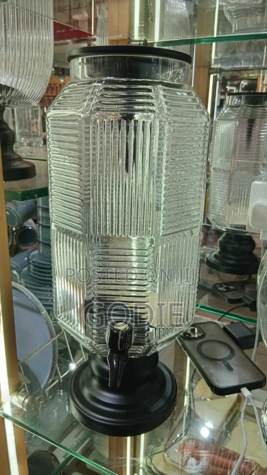 Ribbed Glass Beverage Dispenser With a Black Plastic Lid and Spigot.