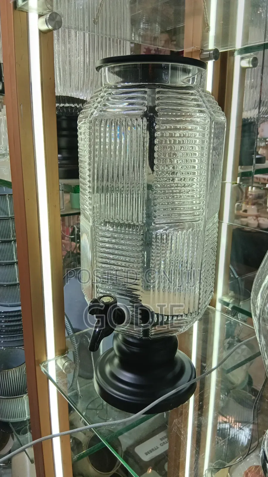 Ribbed Glass Beverage Dispenser With a Black Plastic Lid and Spigot.