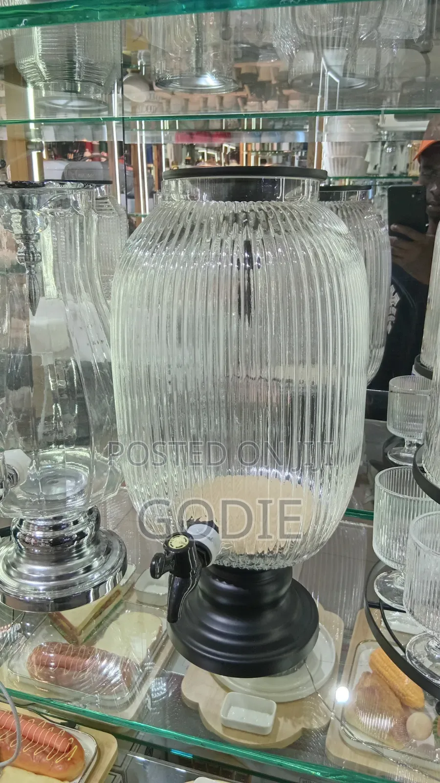 Ribbed Glass Beverage Dispenser With a Black Tap and Stand.