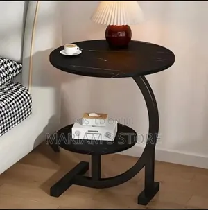 C-Shaped Side Table With a Sleek Black Marble Finish on Its Top]