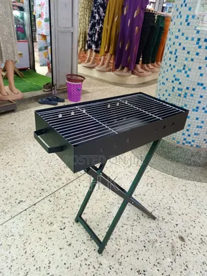 Portable Charcoal Barbecue Grill Featuring a Foldable X-Shaped Stand.