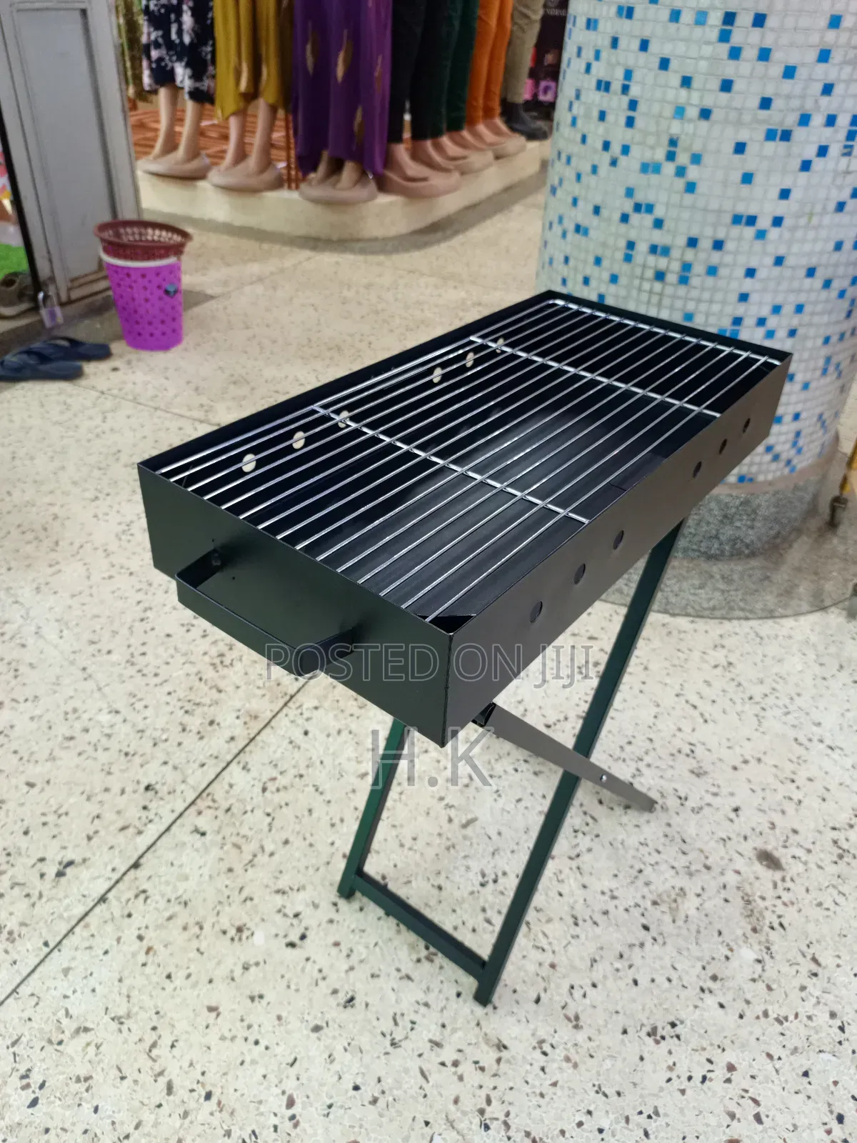 Portable Charcoal Barbecue Grill Featuring a Foldable X-Shaped Stand.