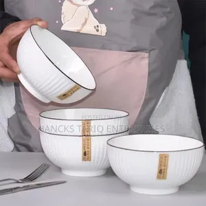 White Ceramic Bowls With Vertical Fluted Ridges and Dark Rims.