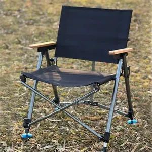 Portable Folding Camping Chair With a Fabric Seat and Wooden Armrests.