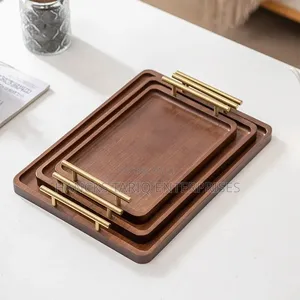 Set of Nested Wooden Serving Trays With Gold Handles.
